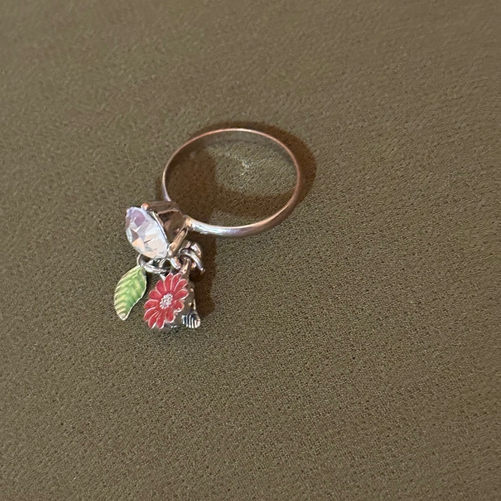charm ring featuring a dangling flower and leaf